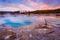 Black Diamond Pool in Biscuit basin with blue steamy water and beautiful colorful sunset. Yellowstone, Wyoming