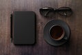 Black diary with glasses and cup of coffee