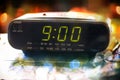 Black digital alarm radio clock.Alarm radio clock indicating time to wake up.Digital clock closeup displaying 9:00 o`clock.Digital