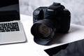 A black digital camera, a tablet and a computer laptop on table Royalty Free Stock Photo