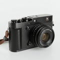 Black digital camera with a vintage design, featuring a textured body and multiple Royalty Free Stock Photo