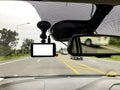 Black digital dashcam camera installed in the car near the rear