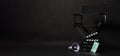 Black director chair , face mask, megaphone and Clapper board or movie slate on black background