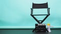 BLACK director chair with megaphone and Clapperboard or movie Clapper board on green or Tiffany Blue and black floor background.it