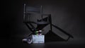 Black director chair and white rainbow Clapper board or movie slate put on floor with megaphone on black background