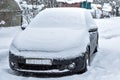 Black dirty car under the snow. Heavy snowfall. Frozen car in snowdrift. winter problems to start engine Royalty Free Stock Photo