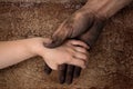 Black dirty man hands holding kid clean hand