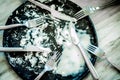 Black dish with fork knife and spoon empty after eat Royalty Free Stock Photo