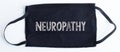 Black disposable protective mask with neuropathy text on black background