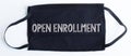 Black disposable protective mask with open enrollment text on black background