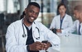 Black doctor, smile and portrait on smartphone in office for medicare, medicine or healthcare with lab coat. Person Royalty Free Stock Photo