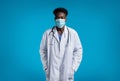 Black doctor wearing face mask physician posing on blue background Royalty Free Stock Photo