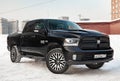 Black Dodge Ram with an engine of 5.7 liters front view on the car parking with snow background