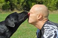 Black dog give kiss man Royalty Free Stock Photo