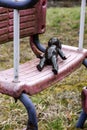 Black doll lying on dirty swing at abandoned playground Royalty Free Stock Photo