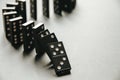 Black dominoes chain on white table background Royalty Free Stock Photo