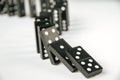 Black dominoes chain on white table background Royalty Free Stock Photo