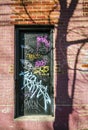 Black door with colored graffiti on a brick wall in a lane in Montreal