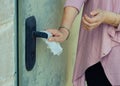 A woman suffering germophobia presses dirty door handle