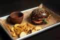 Black double hamburger made from beef, cheese and vegetables. Royalty Free Stock Photo