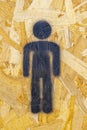 black drawing representative of a man to identify the men's public bathroom under a plywood or chipboard wooden door.
