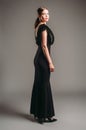 Black dress. Elegant lady in full-length slim sleeveless gown with deep V-neckline. Sensual portrait of a brunette young woman on Royalty Free Stock Photo