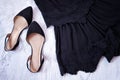 Black dress with embroidery and shoes. Close-up. Fashionable concept