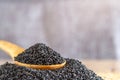 Black dried sesame seed on wooden spoon over wood table