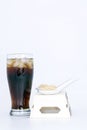 Black drink (cola) and sugar over lettuce over white background Royalty Free Stock Photo