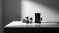 A black drip coffee maker and several ceramic mugs are arranged neatly on a sleek white kitchen countertop Royalty Free Stock Photo