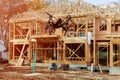 Black drone quadcopter with camera flying over Family Home Construction - Building a New Wood Framed House Royalty Free Stock Photo