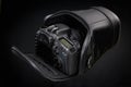 Black DSLR camera isolated on a black background Royalty Free Stock Photo