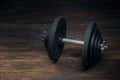 Black dumbbell on dark wooden floor