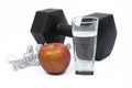Black dumbbells, cup, tape measure and apple on a white background. Royalty Free Stock Photo