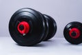 Black dumbbells on a white background. Gym weights on a table. Large dumbbell and small dumbbell for training in the gym Royalty Free Stock Photo