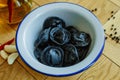 Black dumplings in a white plate on the table. Royalty Free Stock Photo
