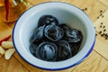 Black dumplings in a white plate on the table. Royalty Free Stock Photo