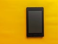 Black E reader on Vibrant Yellow Background Minimalist Design Concept for Modern Technology Royalty Free Stock Photo