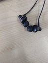 Black earphone with wooden table background for audio design poster