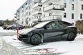 Black electric automobile Tesla Model 3 covered with white snow