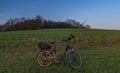 Black electric bicycle with sunset on light green meadow in spring evening