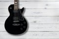 Black electric guitar on a distressed white wooden background Royalty Free Stock Photo