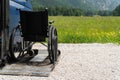 Black electric lift specialized vehicle for people with disabilities. Empty wheelchair on a ramp with nature and Royalty Free Stock Photo