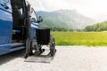 Black electric lift specialized vehicle for people with disabilities. Empty wheelchair on a ramp with nature and Royalty Free Stock Photo