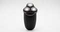 Black electric rotary shaver featuring three circular shaving heads arranged in a Royalty Free Stock Photo