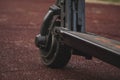 black electric scooter standing on the rubber pad in the park, rear in front Royalty Free Stock Photo