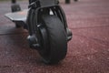 black electric scooter standing on the rubber pad in the park, rear in front Royalty Free Stock Photo