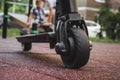 black electric scooter standing on the rubber pad in the park, rear in front Royalty Free Stock Photo