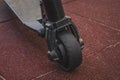 black electric scooter standing on the rubber pad in the park, rear in front Royalty Free Stock Photo