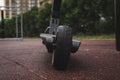 black electric scooter standing on the rubber pad in the park, rear view Royalty Free Stock Photo